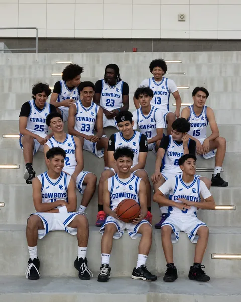 The Chino High School Cowboys laughing together on the stadium steps in white home uniforms