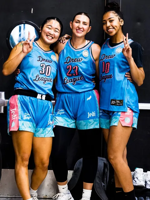 Three Drew League teammates smiling together in turquoise and pink Jedi uniforms
