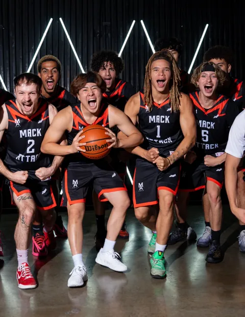 Mack Attack Prep players shouting in black and orange uniforms under a neon light wall